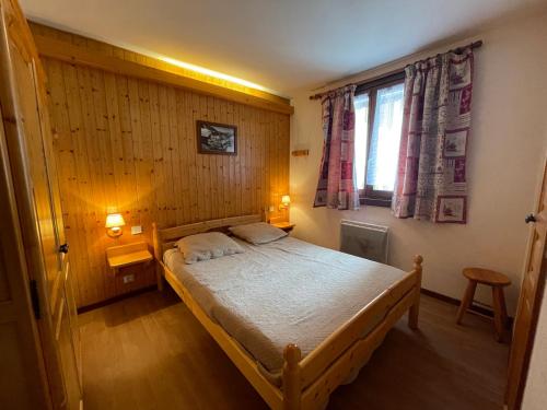 a small bedroom with a bed and a window at Resse - Appartement 3 pieces centre in La Clusaz