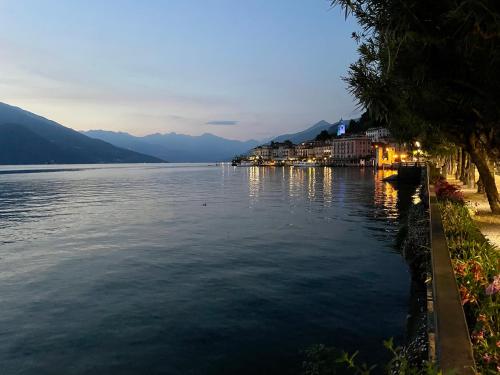 a view of a lake at dusk with buildings on the shore at Bellagio Cool Flat - Private Parking & Rooftop terrace in Bellagio