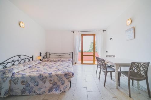 カポリーヴェリにあるResidence Villa Rosiのベッドルーム1室(ベッド1台、テーブル、椅子付)