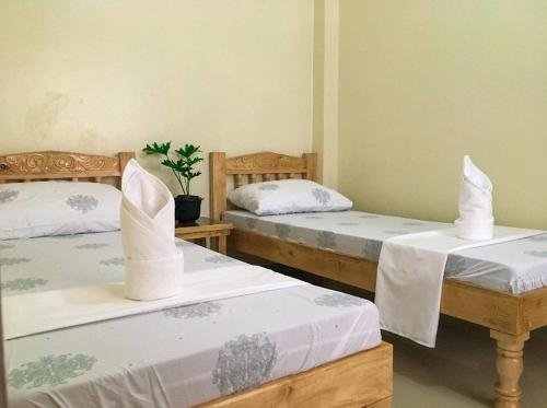 a room with two beds with white sheets at Kylitas transient house- Bohol in Tagbilaran City