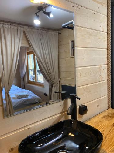 a bathroom with a black sink in front of a mirror at Rajski Domek in Sadowie