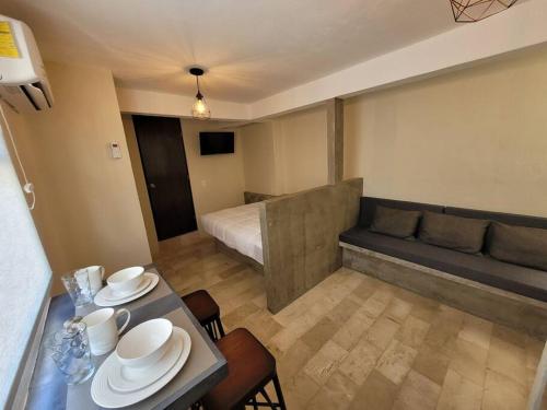 a room with a bed and a table with dishes on it at D-08NOVAGA DOWNTOWN CANCUN in Cancún