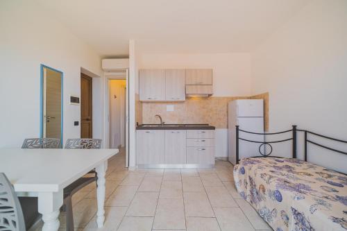 a kitchen with a table and a bed in a room at Residence Villa Rosi in Capoliveri