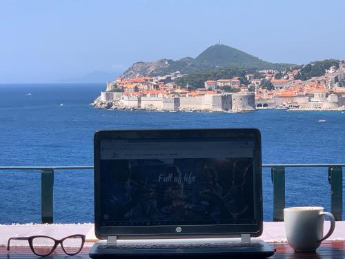 a laptop computer sitting on a table with a cup of coffee at Beach house Sveti Jakov in Dubrovnik