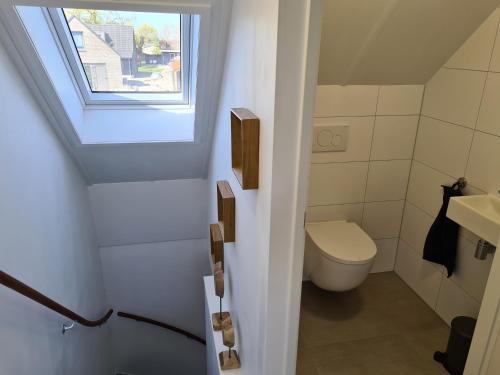 a bathroom with a toilet and a window at Bungalow 76 op Recreatiepark de Wielen in Sint Maarten