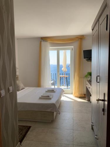 a bedroom with a bed and a view of the ocean at Beach house Sveti Jakov in Dubrovnik