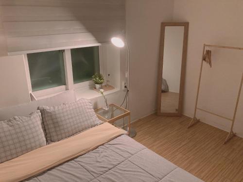 1 dormitorio con cama, ventana y lámpara en Yakorea Hostel Dongdaemun, en Seúl