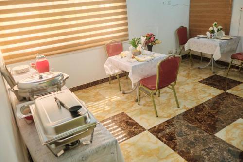 een restaurant met 2 tafels en stoelen en een tafel met eten erop bij Covenant Hotel in Accra