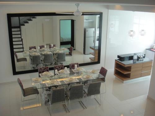 a dining room with a table and chairs and a mirror at Batu Ferringhi - Shamrock Beach Villas, Penang in Batu Ferringhi