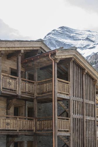 a wooden building with a mountain in the background at Polaris 1 006 - LUXE & SKI LIFT apartment 6 pers in Zinal