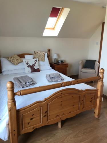 a bedroom with a large wooden bed and a chair at Druid View B&B in Inverness