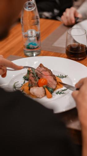 a plate of meat and vegetables on a table at Hotel Theatro- City Center in Tirana