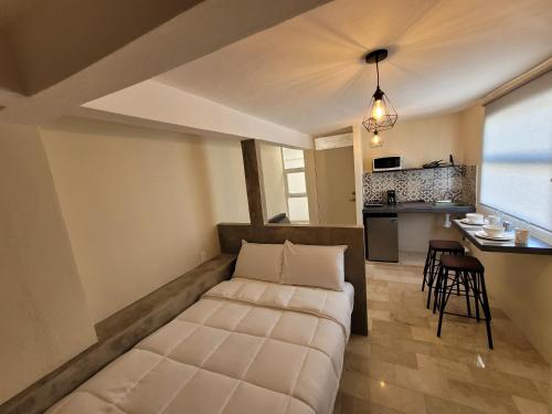 a bedroom with a bed in a room with a kitchen at D-08NOVAGA DOWNTOWN CANCUN in Cancún
