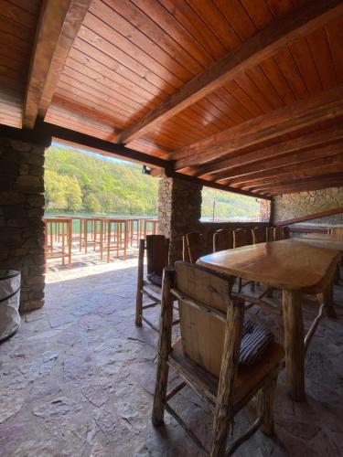 a wooden table and chairs under a wooden roof at Holiday Houses Green Queen in Bihać