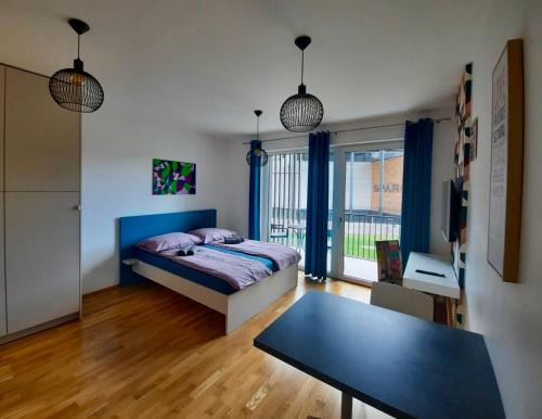 a bedroom with a blue bed and a table at Lux Optim Bled in Bled