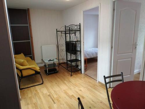 ein Wohnzimmer mit einem Zimmer mit einem Tisch und einem Stuhl in der Unterkunft Superbe appartement avec parking gratuit sur place in Nancy