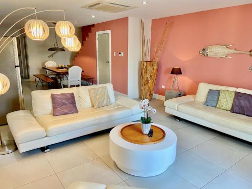 a living room with two white couches and a table at Las Islas Condo #1 in Palm-Eagle Beach