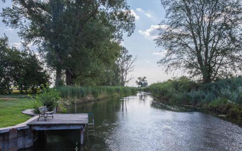 a bench sitting on a dock next to a river at SOHL FARM Apartments in Neutrebbin
