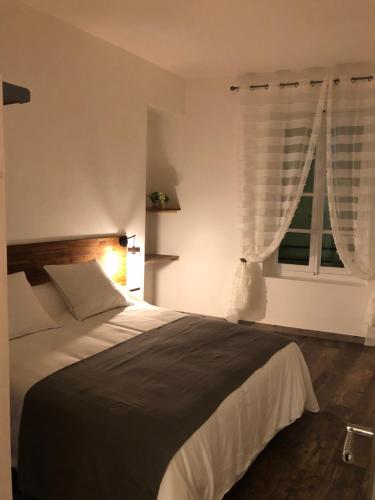 - une chambre avec un grand lit et une fenêtre dans l'établissement Appartement Centre Historique, à Bergerac