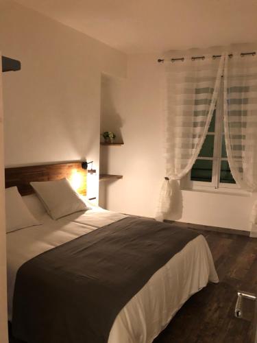 une chambre avec un grand lit et une fenêtre dans l'établissement Appartement Centre Historique, à Bergerac