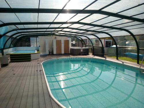 a large swimming pool in a building with a roof at Campsie Glen Holiday Park in Fintry
