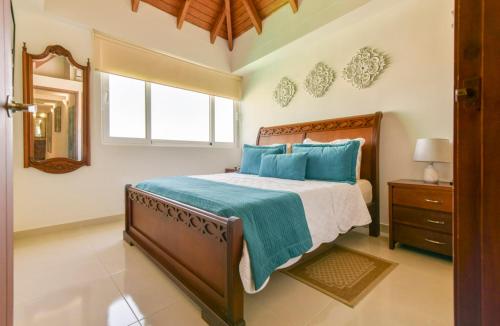 a bedroom with a bed with blue pillows and a mirror at PENTHOUSE AGUAMARINA in San Andrés