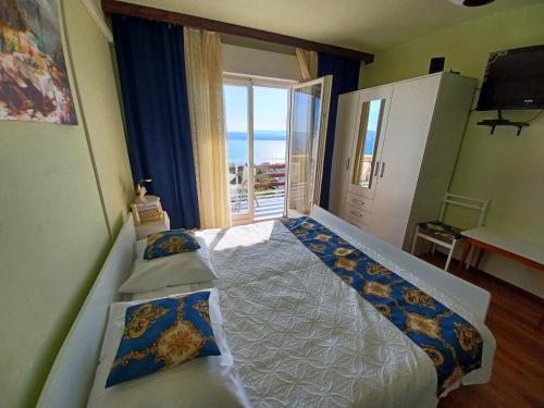 a bedroom with two beds and a large window at Guest House Djurdjica in Dramalj