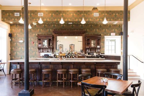 a bar in a restaurant with wooden stools at Fort Conde Inn - Mobile in Mobile