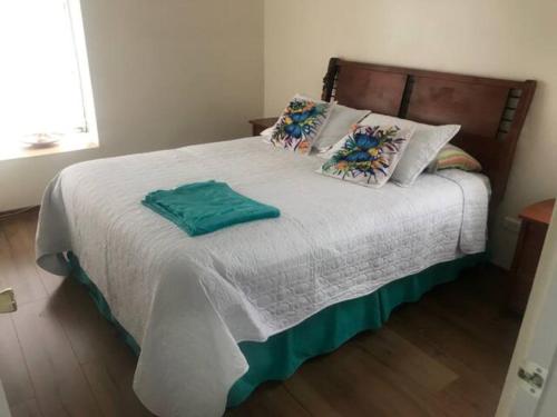1 dormitorio con 1 cama grande con sábanas y almohadas blancas en Hermoso Depto Vista al Valle, en Rancagua