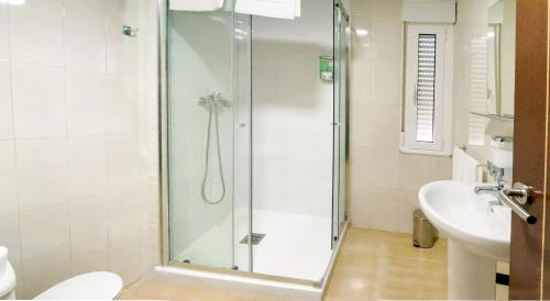a bathroom with a shower and a toilet and a sink at Hostal Restaurante Cuatro Caminos in Cubillos del Sil