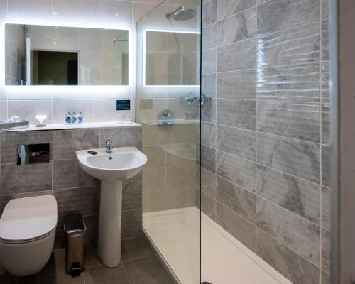 y baño con ducha, aseo y lavamanos. en Da Vinci's Hotel en Derry