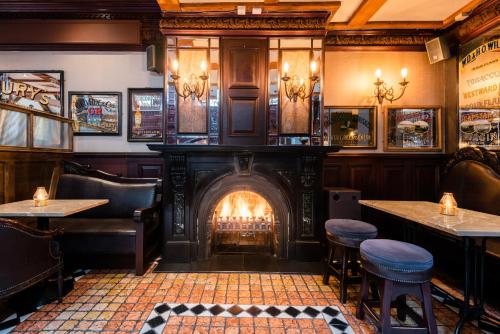 a fireplace in a restaurant with tables and chairs at Da Vinci's Hotel in Derry Londonderry