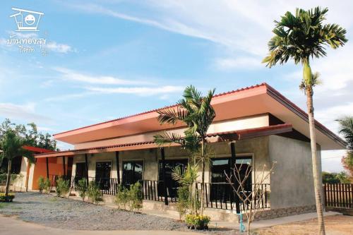 a house with palm trees in front of it at บ้านทองสุข รีสอร์ท in Ban Dao Ruang