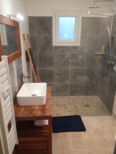 une salle de bain avec un lavabo et une douche dans l'établissement Maison de vacances 2 chambres wifi à 400 m de la plage, à Les Moutiers