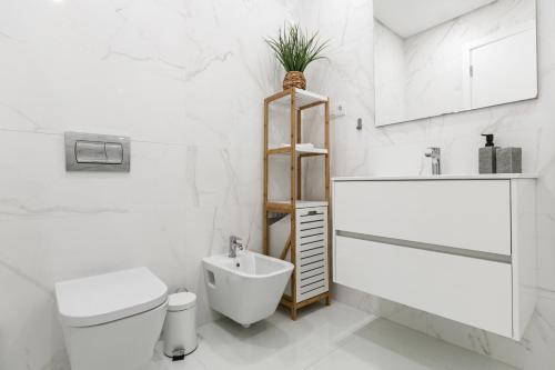 een witte badkamer met een toilet en een wastafel bij Consolação Surf & Beach House in Consolacao