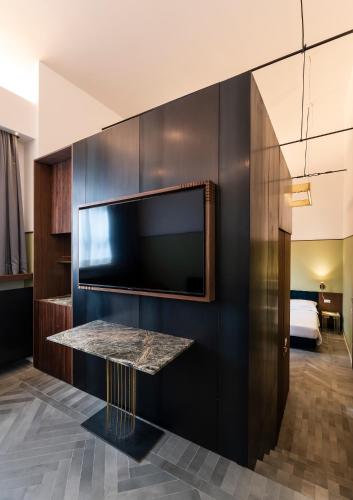 a hotel room with a flat screen tv on a wall at Horti 14 Borgo Trastevere Hotel in Rome