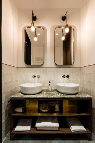 two sinks in a bathroom with two mirrors at Horti 14 Borgo Trastevere Hotel in Rome