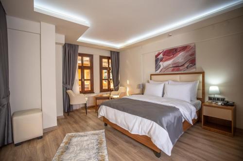 a hotel room with a large bed and a desk at Kutlucan Oldtown in Bursa