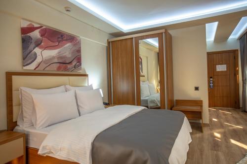 a bedroom with a large bed and a large mirror at Kutlucan Oldtown in Bursa