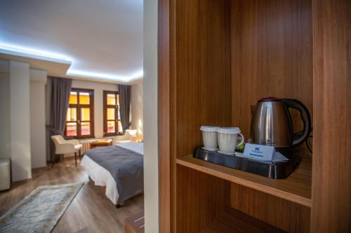 a hotel room with a bed and a coffee maker on a shelf at Kutlucan Oldtown in Bursa