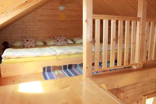 a log cabin with a bed in the attic at Drevenica Trnovec in Liptovský Trnovec