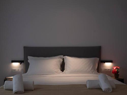 a large bed with white sheets and pillows on it at Electra Luxury Apartment at the Heraklion Center in Heraklio Town