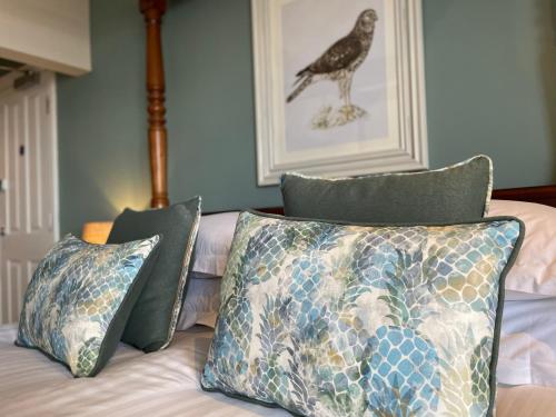 a bed with pillows and a picture of a bird on the wall at The Ship in Parkgate