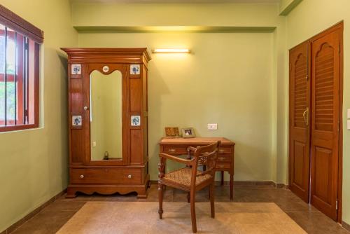 a room with a desk and a chair and a mirror at Saffronstays Casa Del Palms, Alibaug - luxury pool villa with chic interiors, alfresco dining and island bar in Alibaug