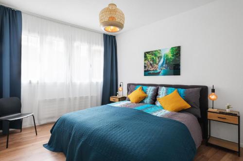 um quarto com uma cama azul e almofadas amarelas em Spirit Apartments - Zentral am See - Parkplatz em Brienz