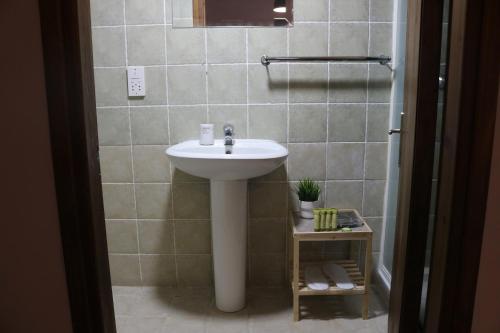 a bathroom with a white sink and a mirror at Semiramis Hotel in Platres