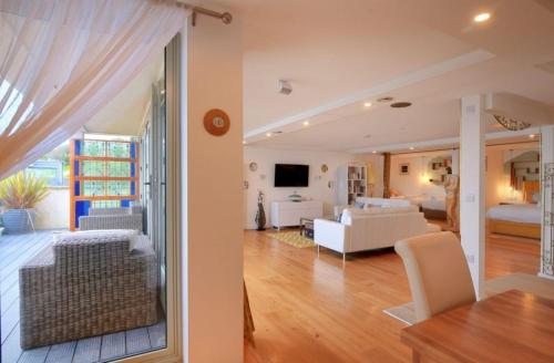a living room with white furniture and a dining room at Largigi offering two amazing panoramic sea front apartments in Lyme Regis