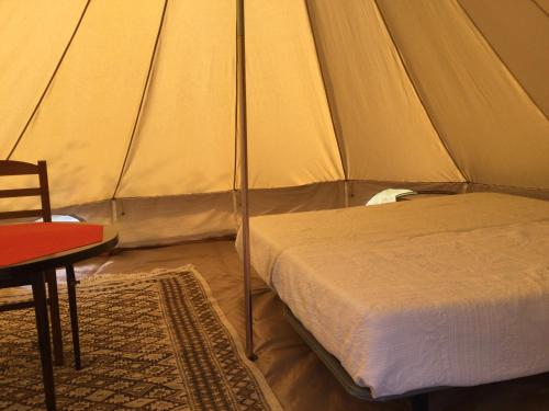 a bedroom with a bed in a tent at EcoCamping d Hacadour in Mellionnec