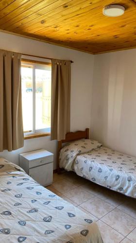 a bedroom with two beds and a window at El Pino in Trenque Lauquen