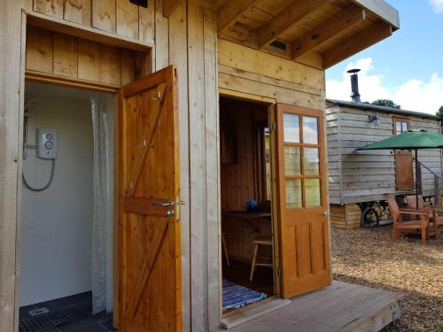 an outside door of a wooden house with an open door at Cozy Cabine Retreat in Clun in Craven Arms